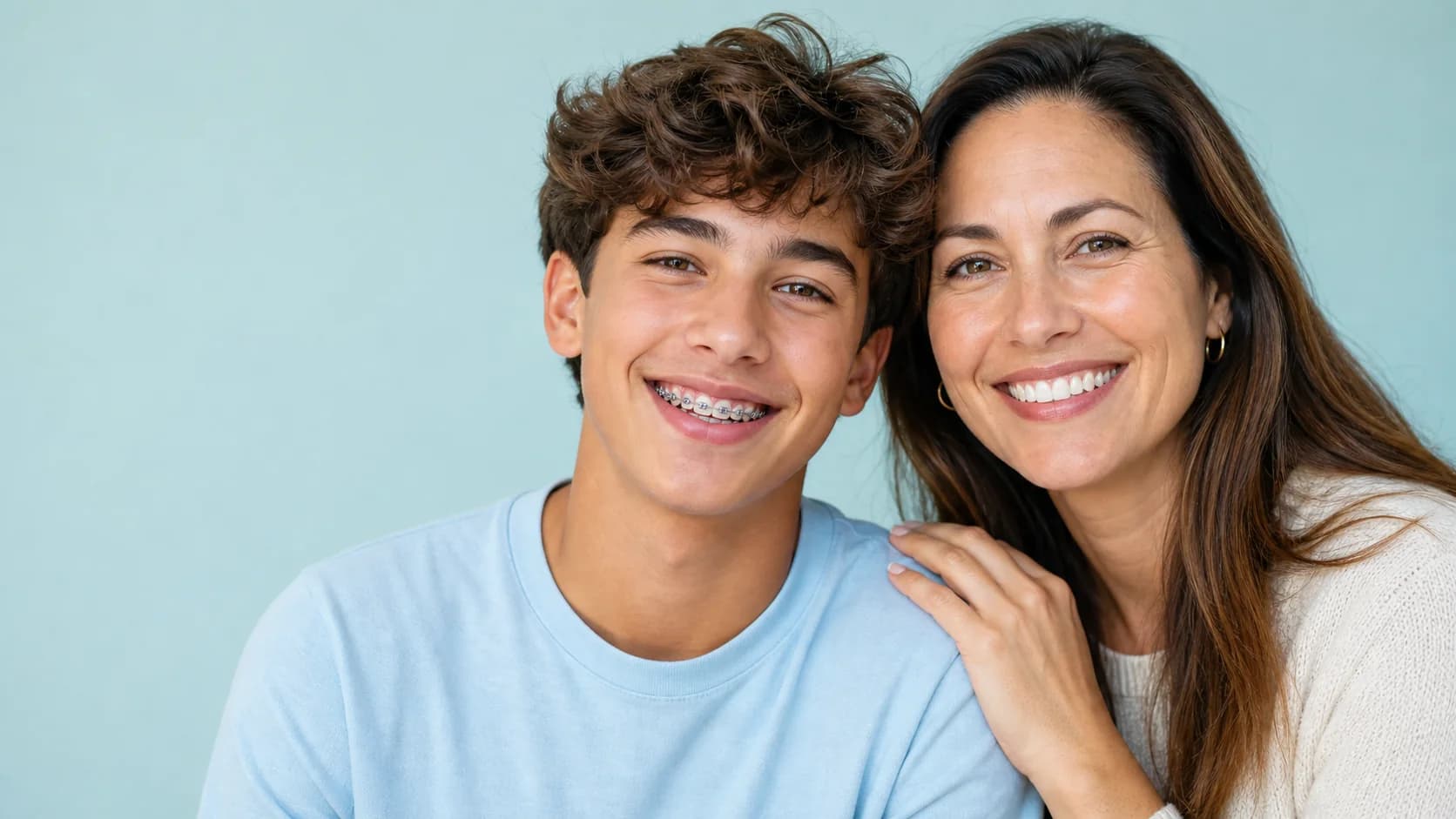 Teen wearing braces smiling with his mother